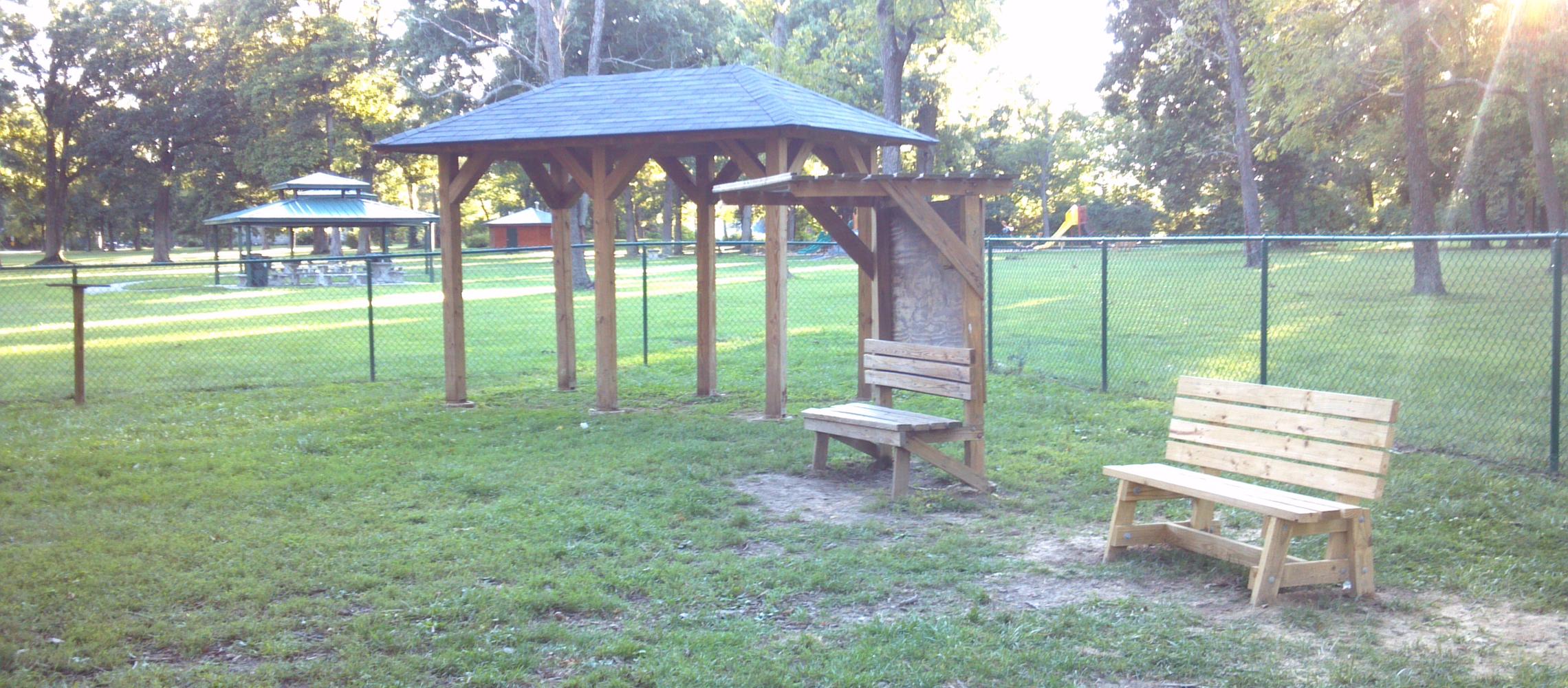 Corner of dog park facing outdoor shelters and children's playground Corner of dog park facing outdoor shelters and children's playground