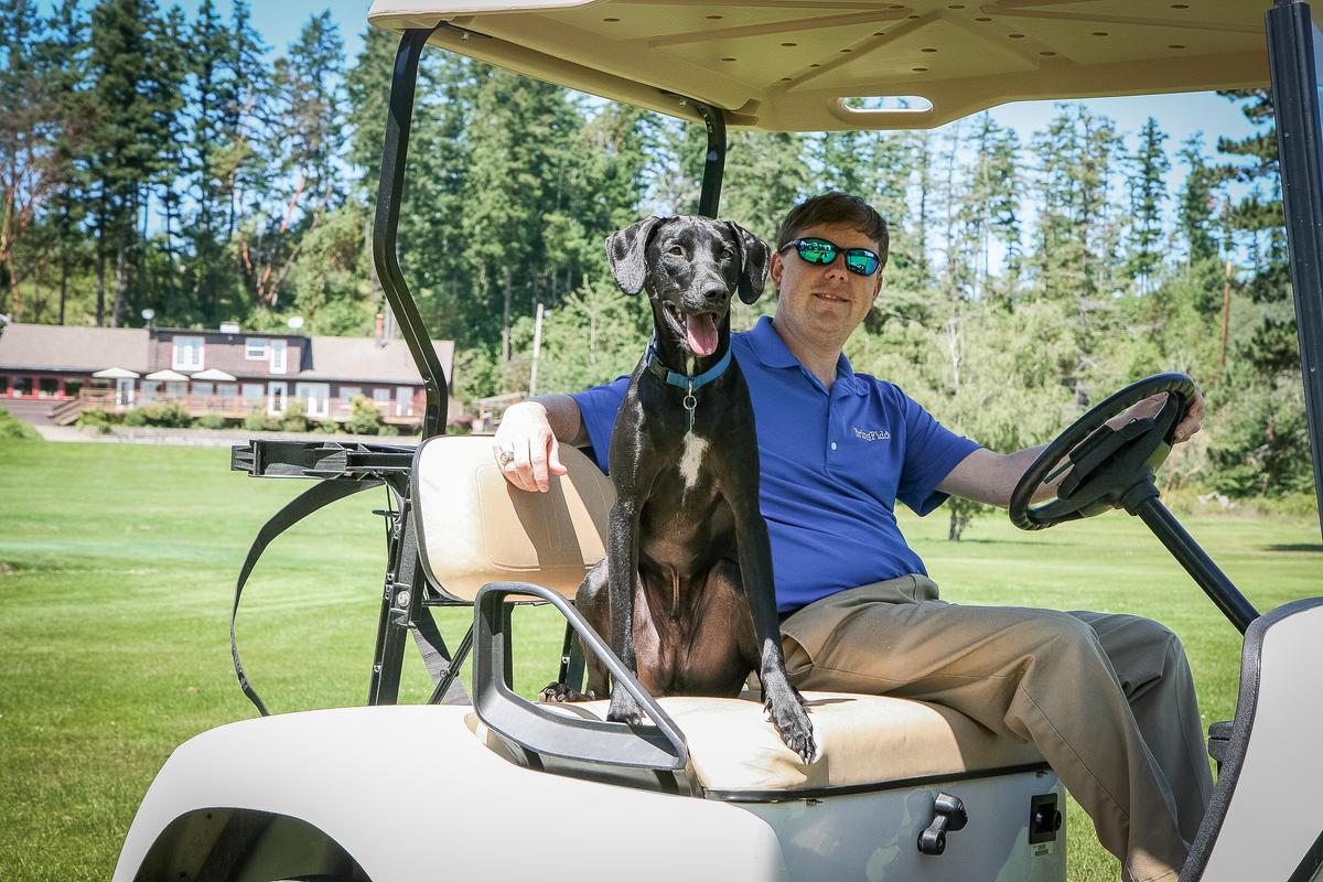 Man and His Dog Ride on a Golf Cart