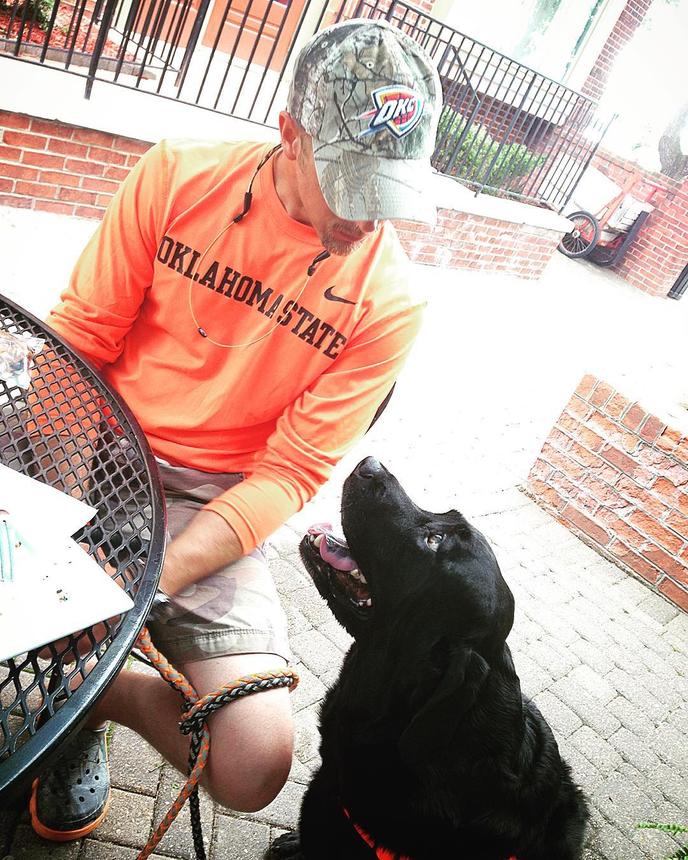 Visit the Sugar Leaf Bakery & Cafe in Dog-Friendly Branson, MO. A Man Sits With His Dog on the Patio of the dog-friendly Sugar Leaf Bakery & Cafe in Branson, MO.