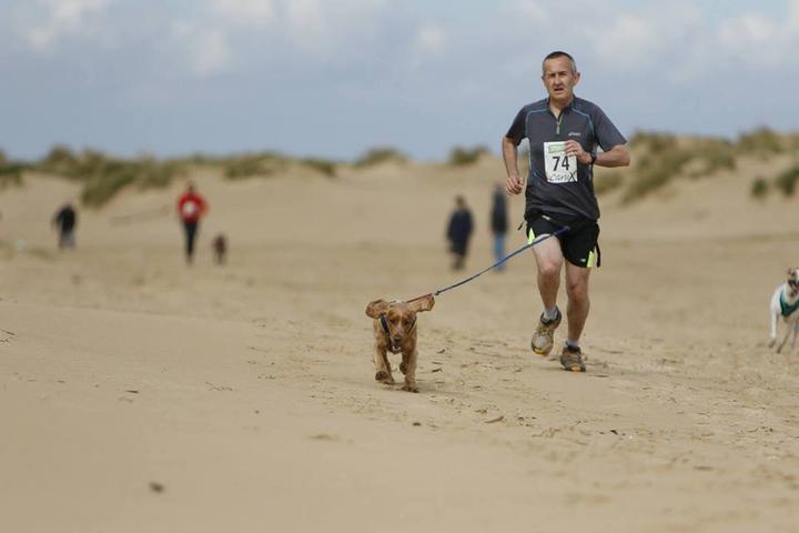 A man and his dog compete at a Canicross event.