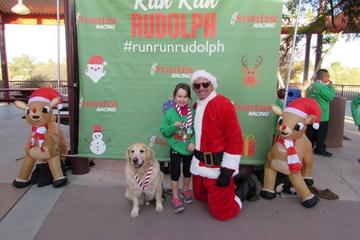 The Tucson Run Run Rudolph Half Marathon Is a Pet-Friendly Christmas Race in Tucson. A Man Dressed as Santa Poses With a Girl and a Dog at a Pet-Friendly Christmas Race in Arizona.