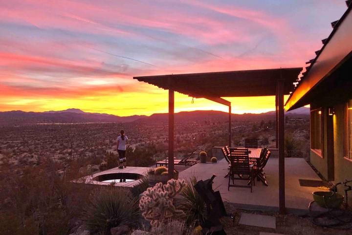 A Person Looks at a Desert Sunset From the Patio of a Secluded Pet-Friendly Airbnb Rental.