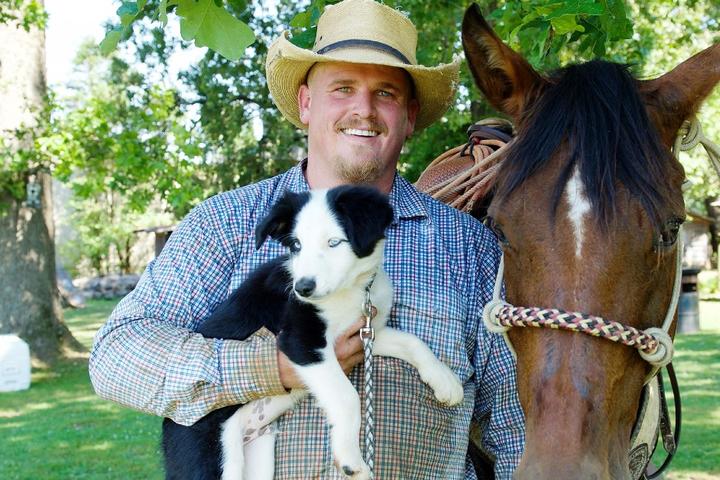 Cowboy and horse and dog at pet-friendly Seventy Four Ranch in Georgia.