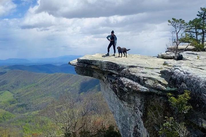 A hiker and his dog reach McAfee Knob on the Appalachian Trail.