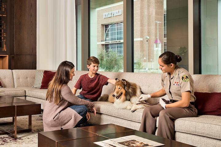 A woman, two kids, and a dog relax at a pet-friendly hotel in Texas