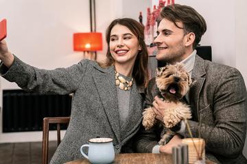 Reservation for 3: Valentine's Day Dinner With Fido A couple and a dog take a selfie at dinner