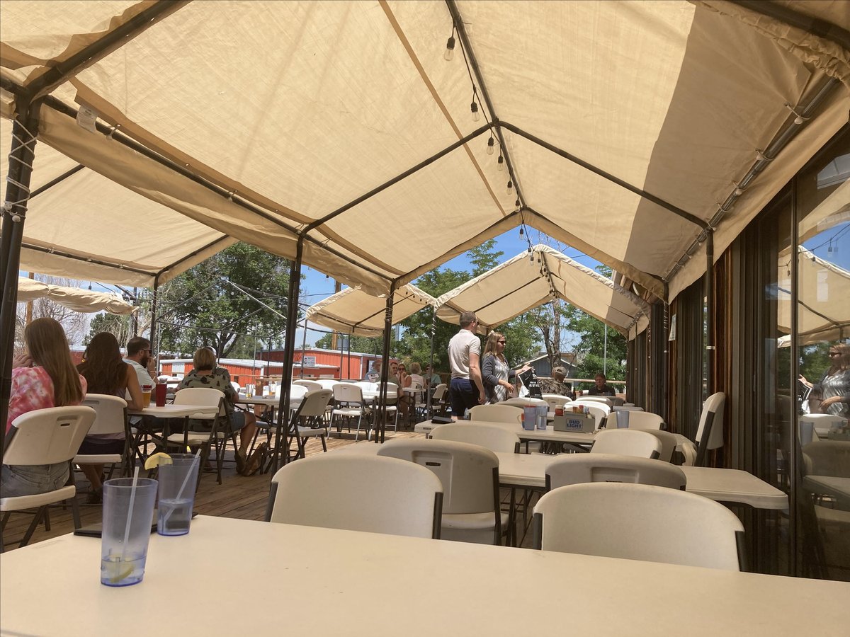 A photo of the partially shaded outdoor deck at The Ermerald Isle, a pet-friendly restaurant in Aurora, CO.