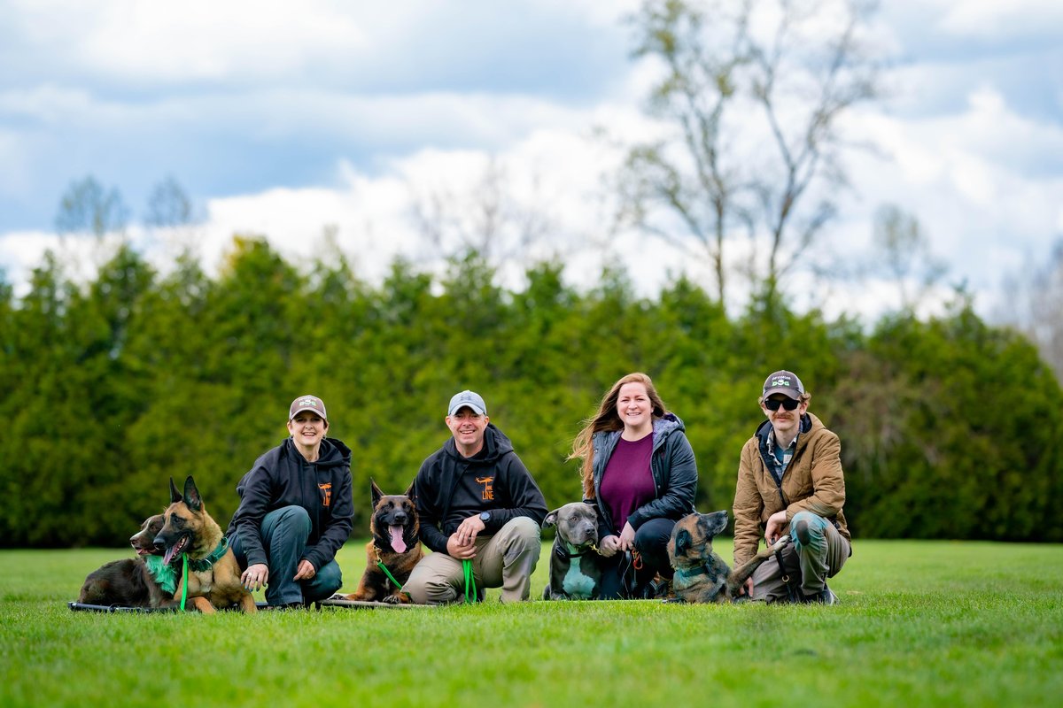 A group of trainers employed by pet-friendly service Optimum Dog in Mount Venon, WA, pose for a photo.