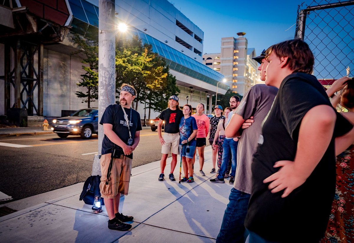 A guide shares a story with attendees during a pet-friendly activity in Fall River, MA, US Ghost Adventures tour.